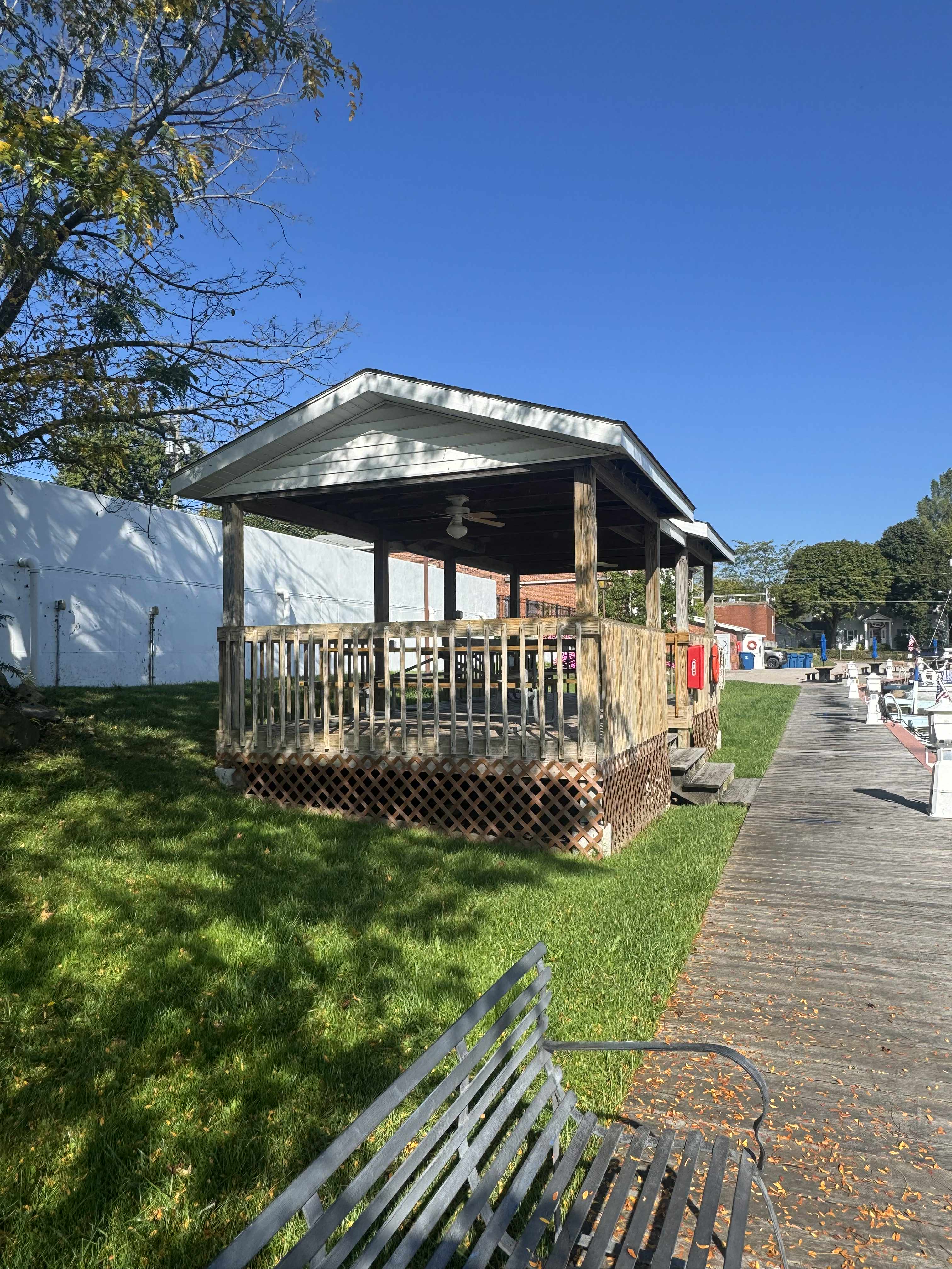 wood shelter with white roof on the side of a wooden walkway